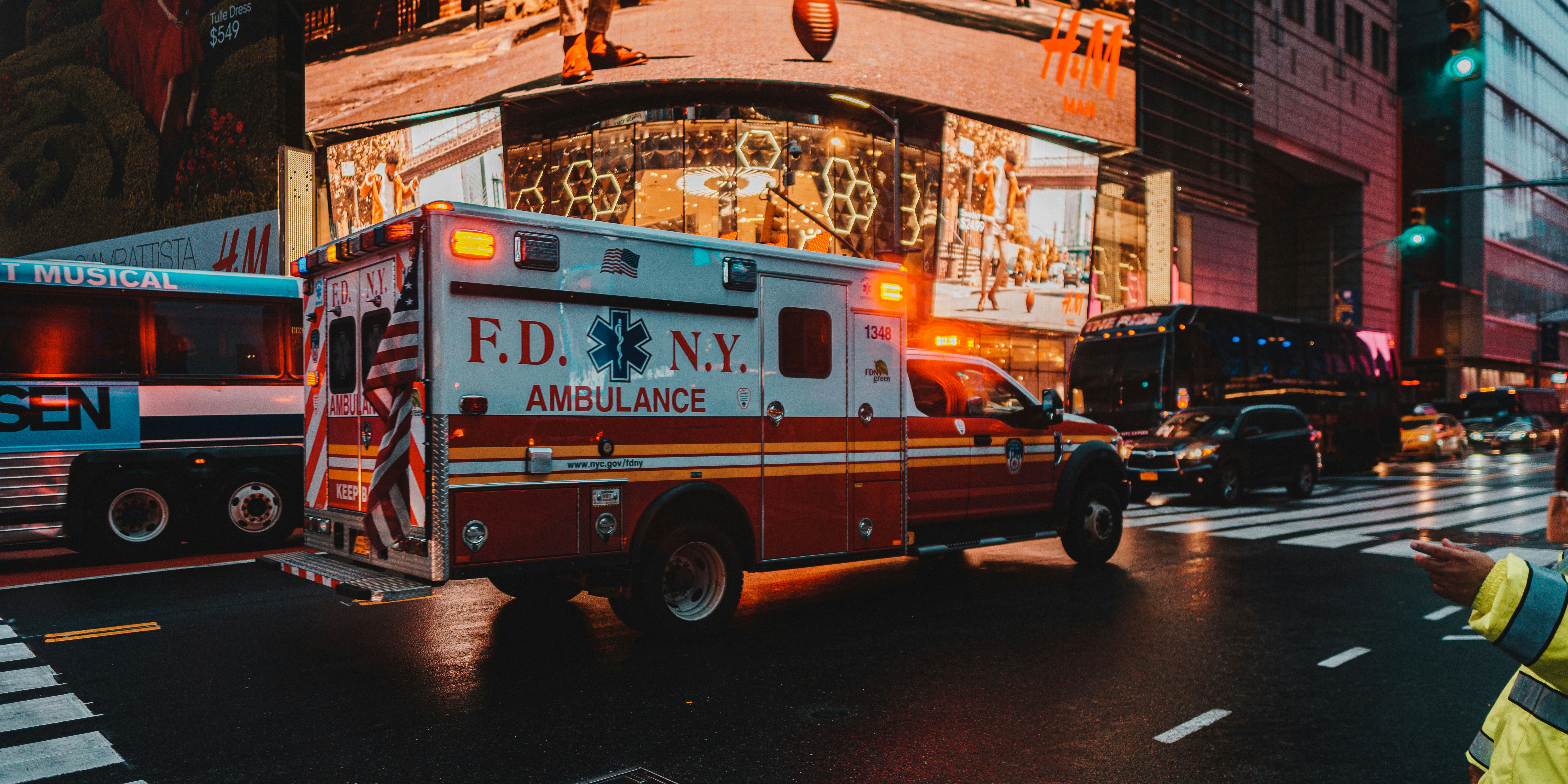an ambulance is driving down a busy city street