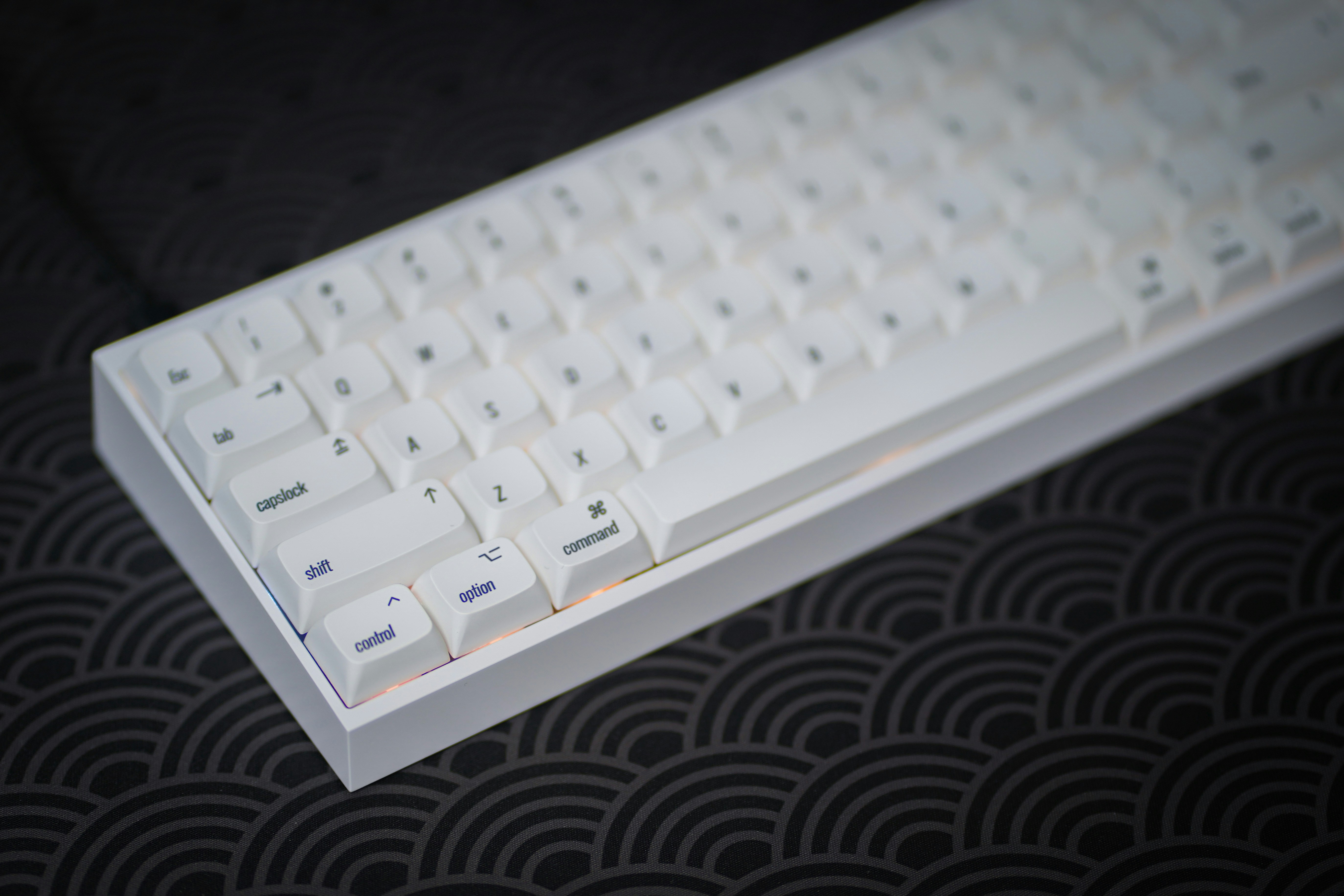 a close up of a white keyboard on a black surface