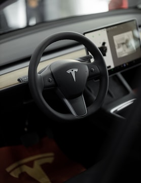 a car dashboard with a steering wheel and a display screen