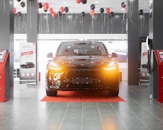 a car is parked in a showroom with balloons