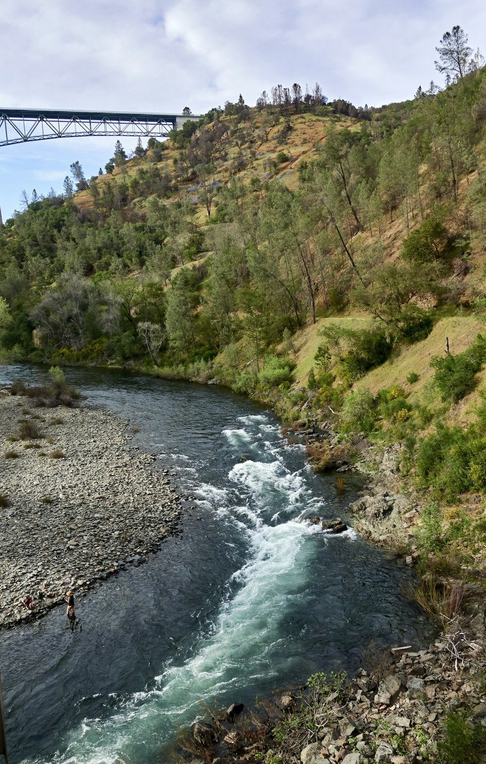 a river running through a lush green hillside