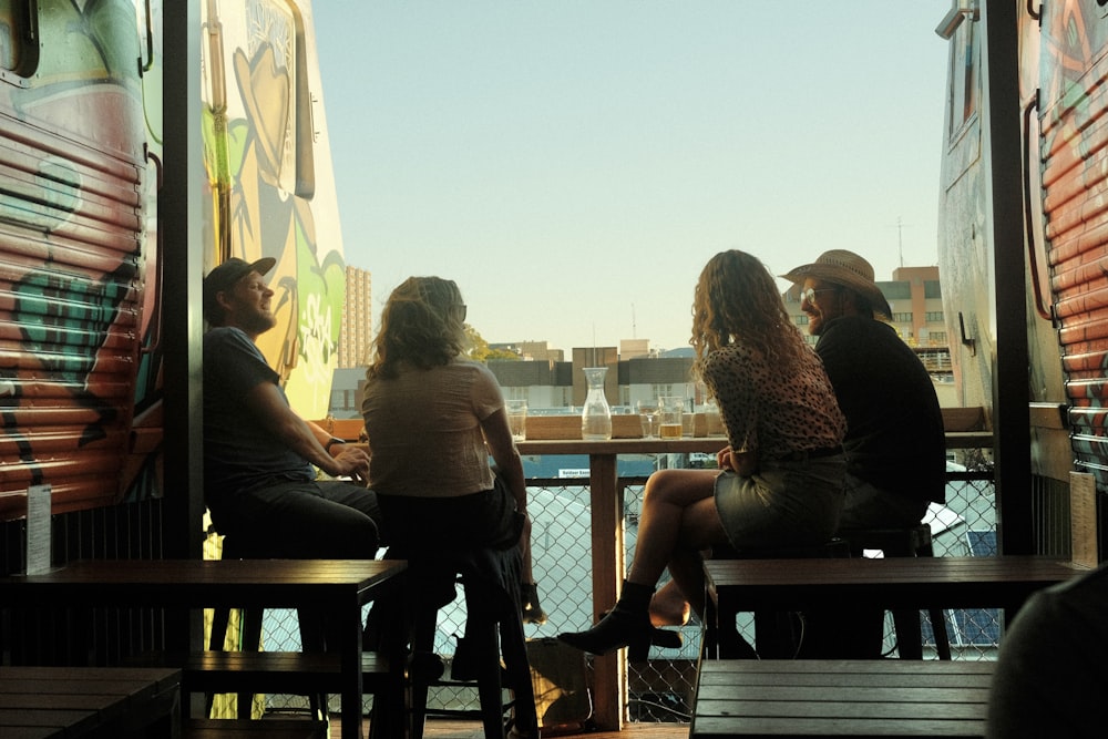 a group of people sitting on top of a wooden bench