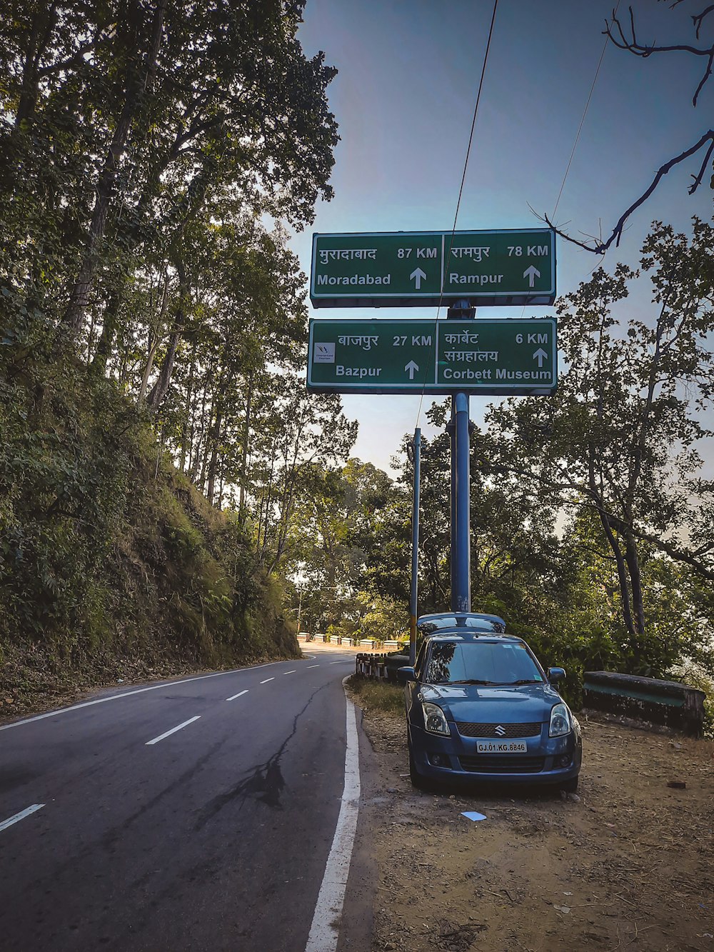 a car parked on the side of a road next to a street sign