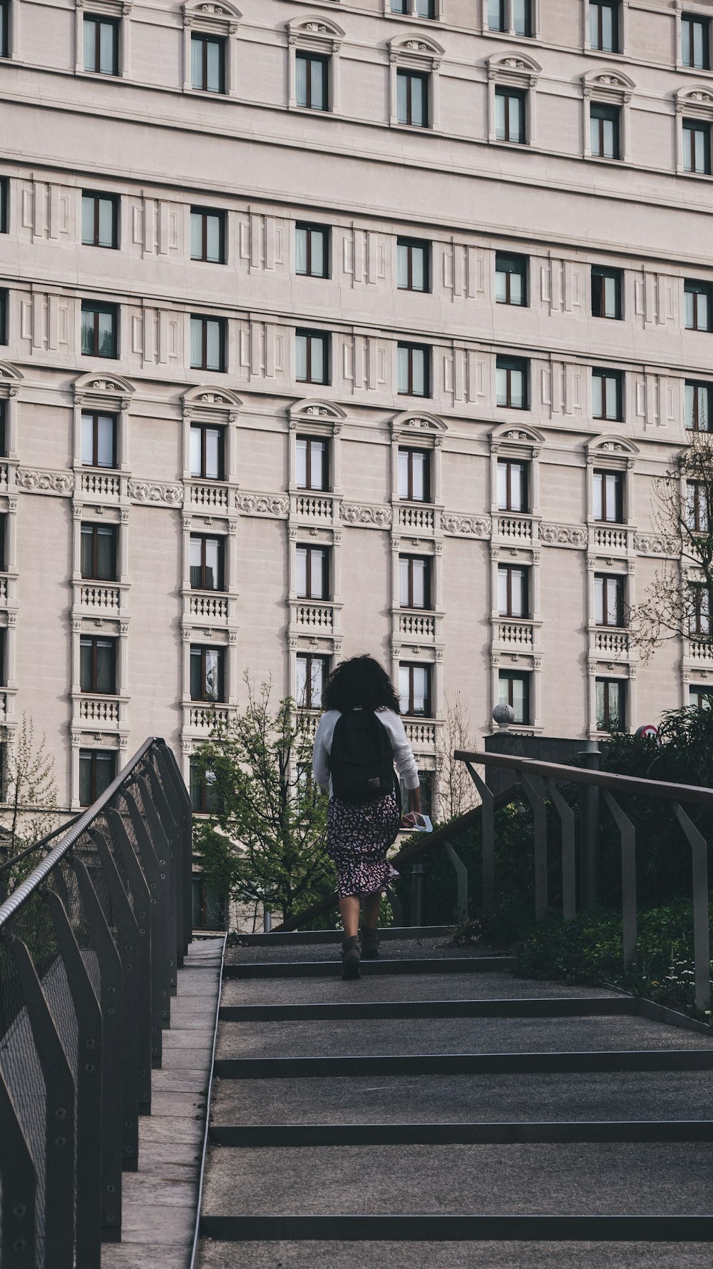 a woman walking down a flight of stairs with an umbrella