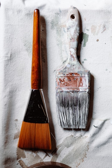 a paintbrush and a paint can sitting on a piece of paper
