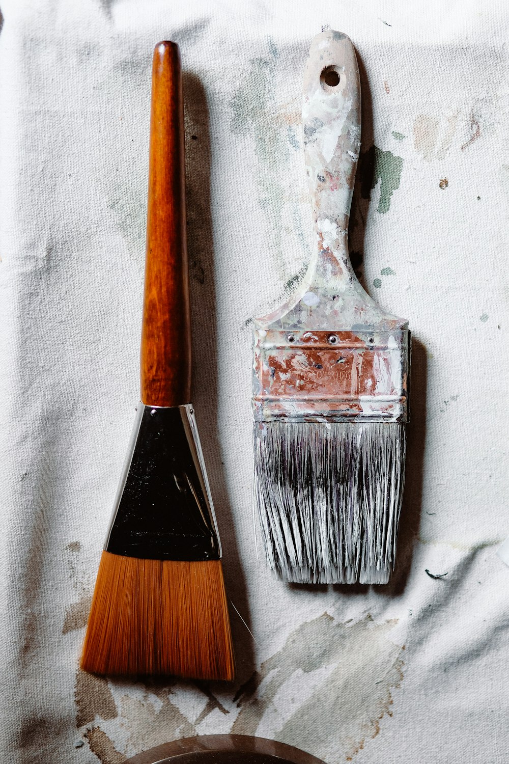 a paintbrush and a paint can sitting on a piece of paper