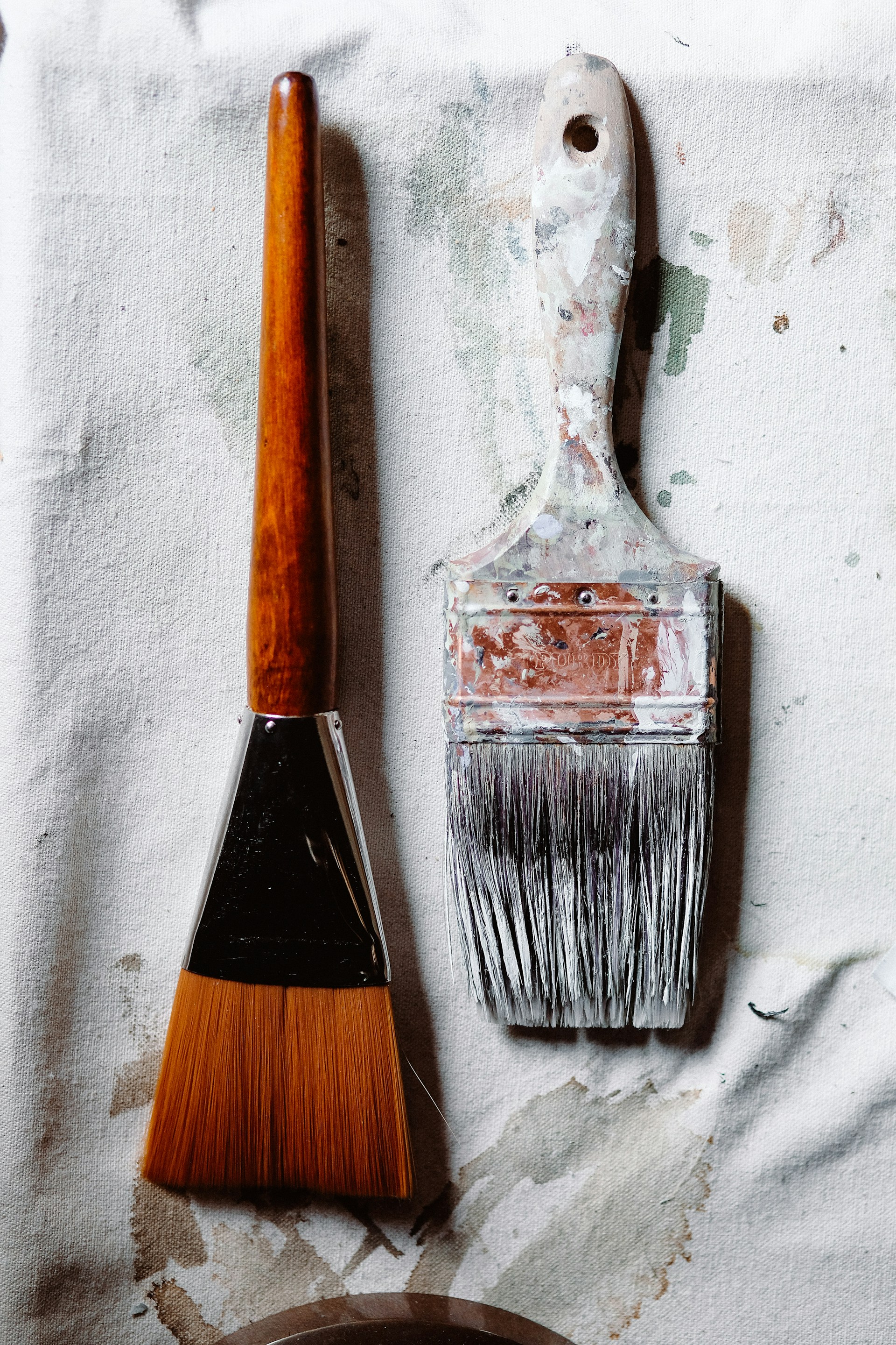 a paintbrush and a paint can sitting on a piece of paper