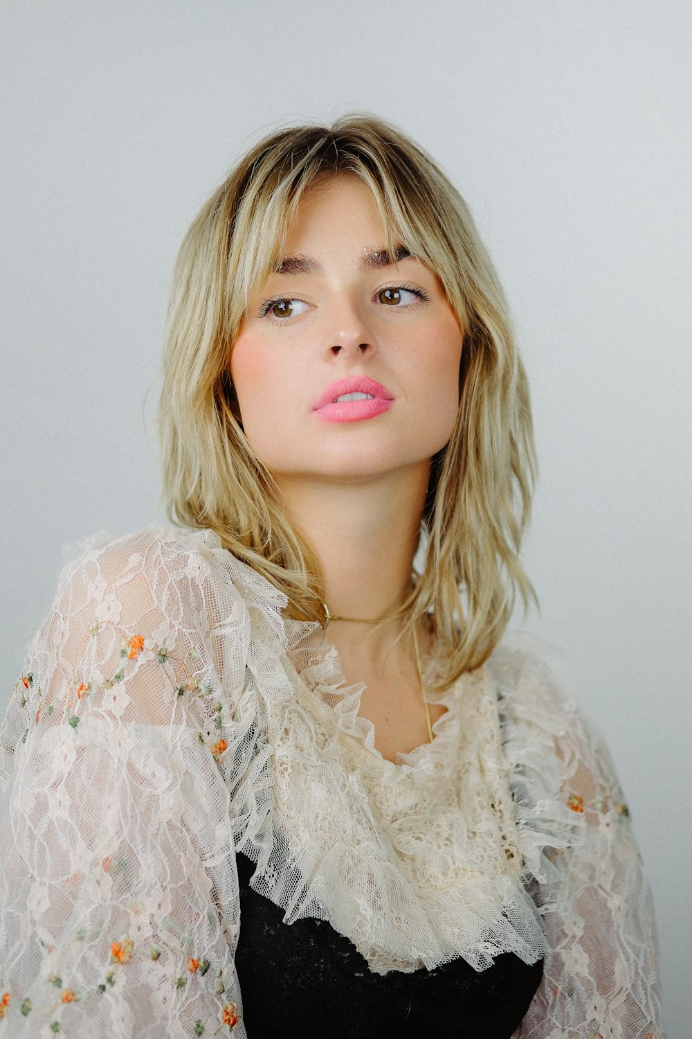 a woman with blonde hair wearing a white blouse