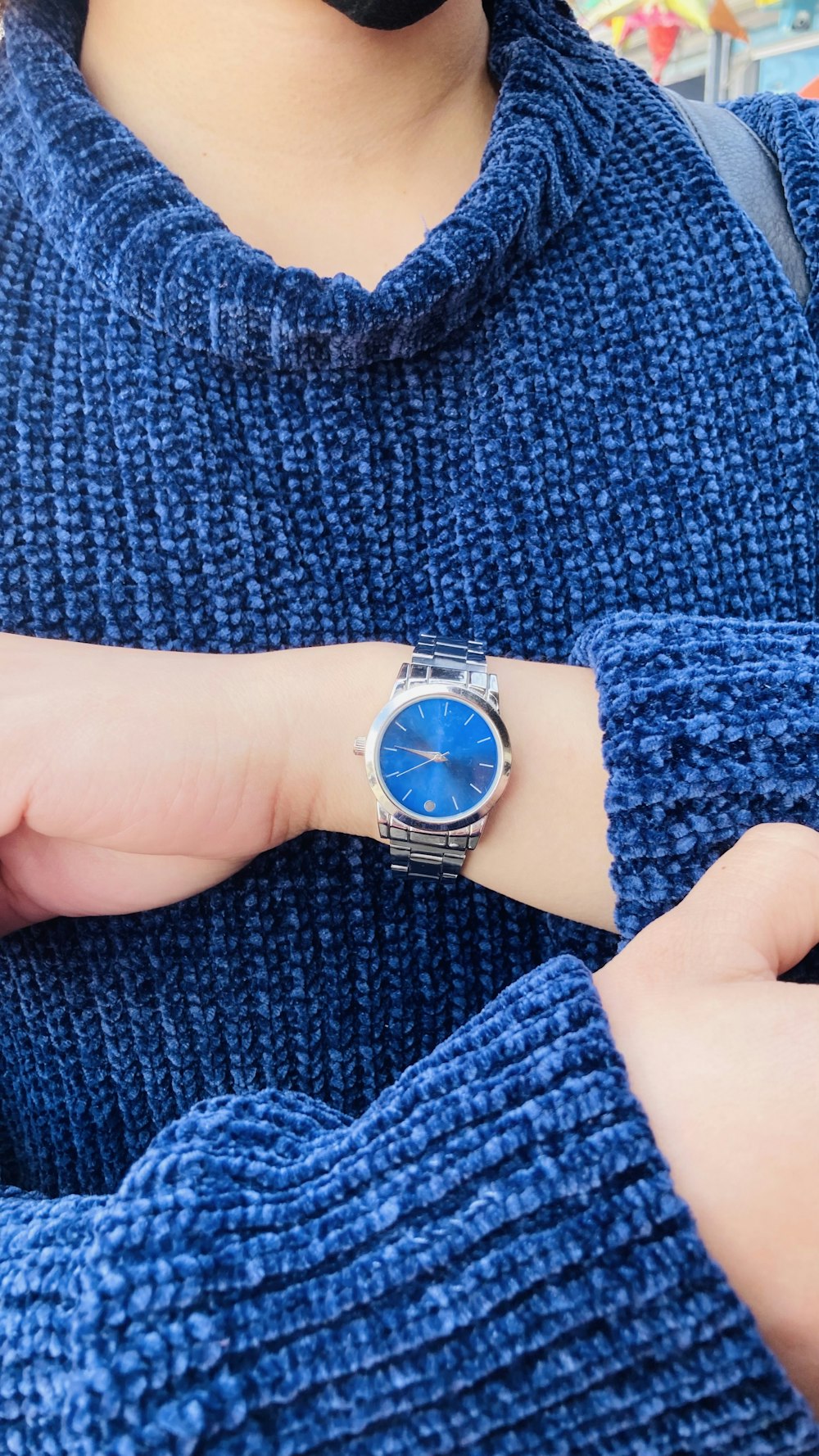 Una mujer con un suéter azul y un reloj