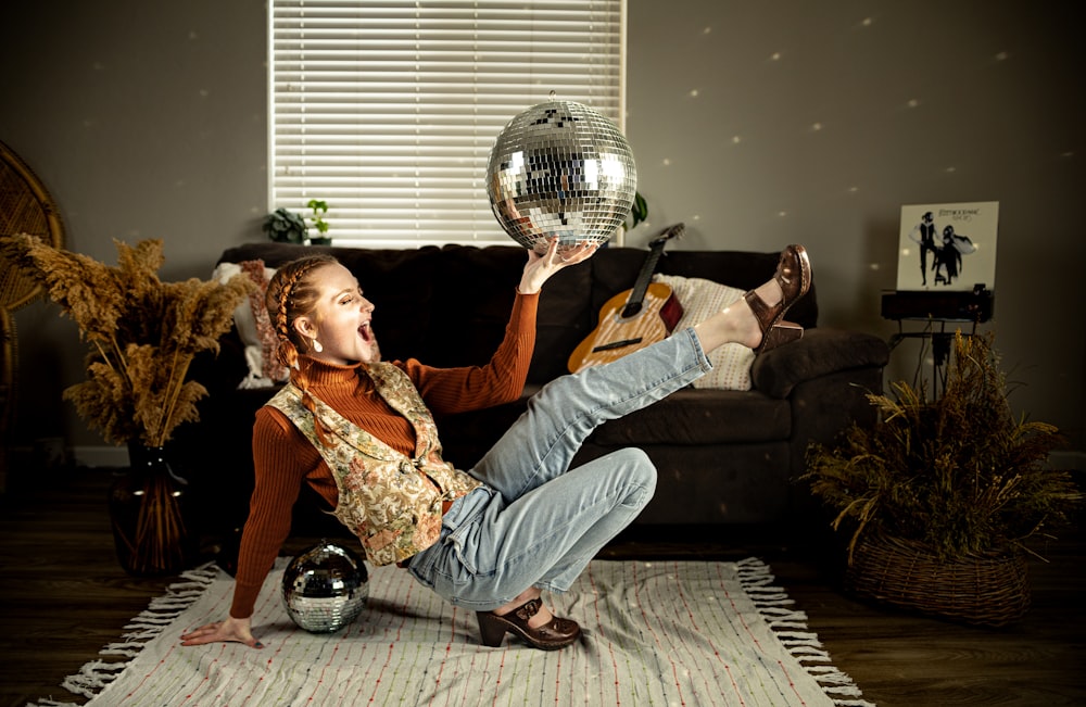 a woman is holding a disco ball in her hands