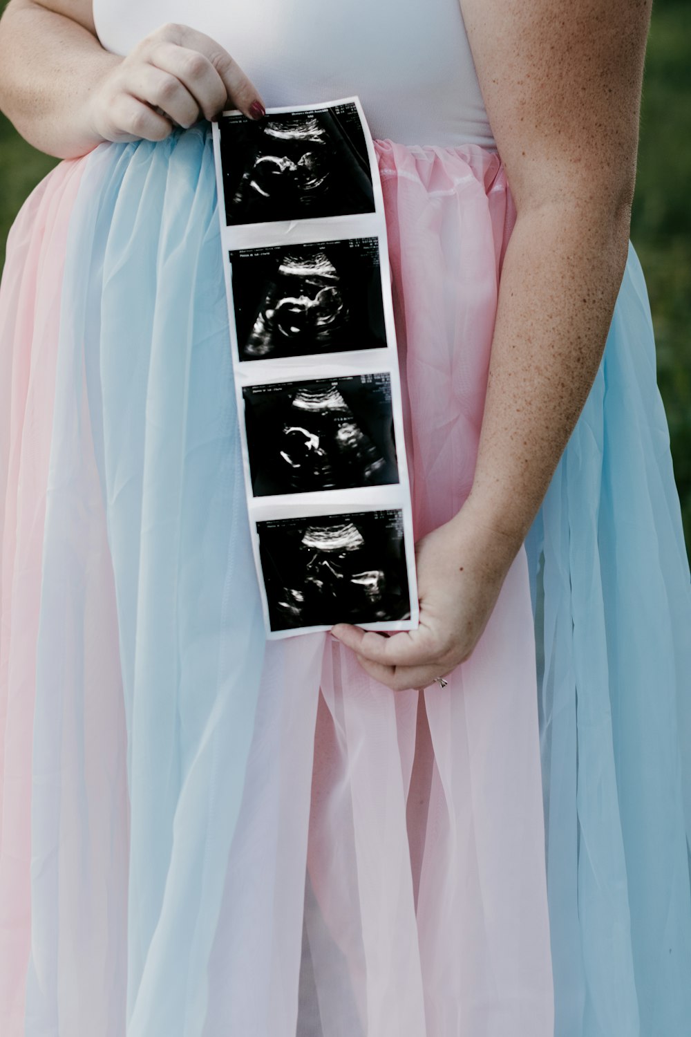 a woman in a dress holding a box with pictures on it