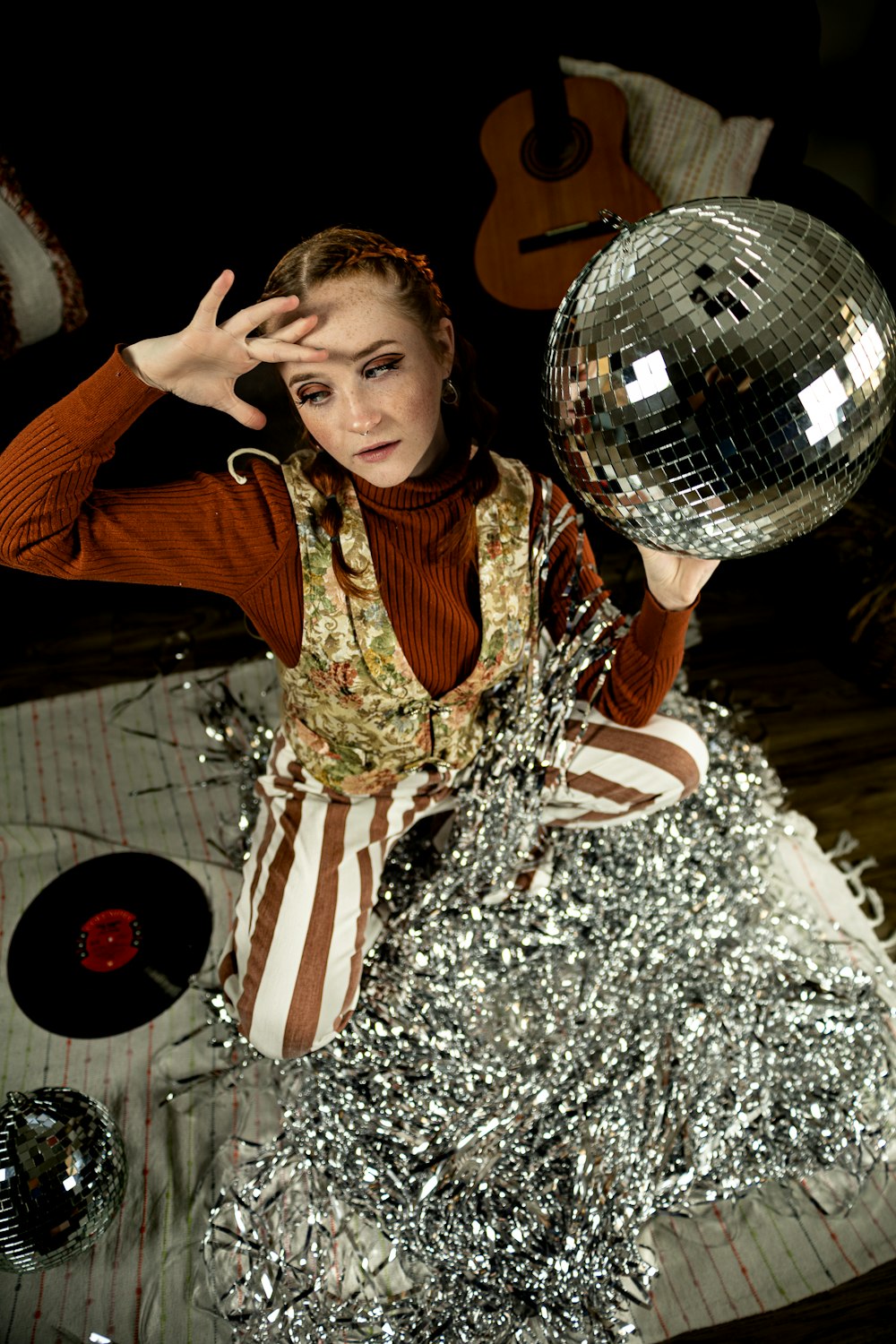 a woman holding a disco ball on top of a table