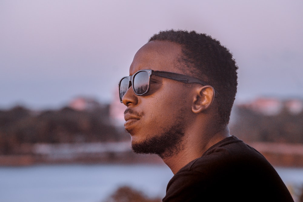 a man with a beard and sunglasses looking off into the distance