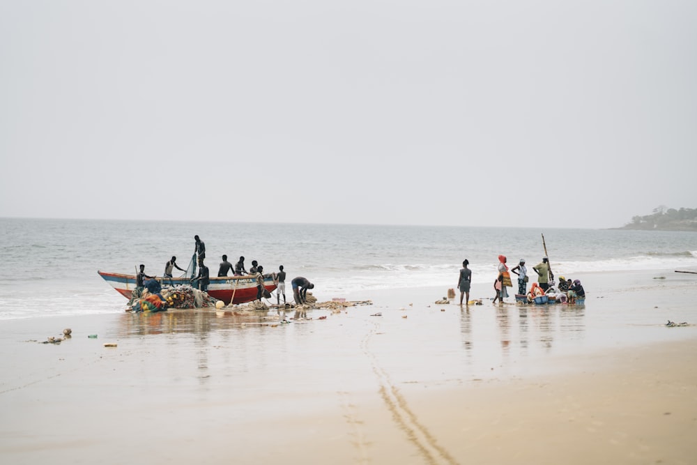 a group of people standing on top of a sandy beach