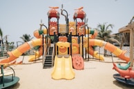 Colorful indoor and outdoor play equipment set up in a sunny playground.