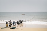 a group of people standing on top of a sandy beach