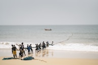 a group of people standing on top of a sandy beach