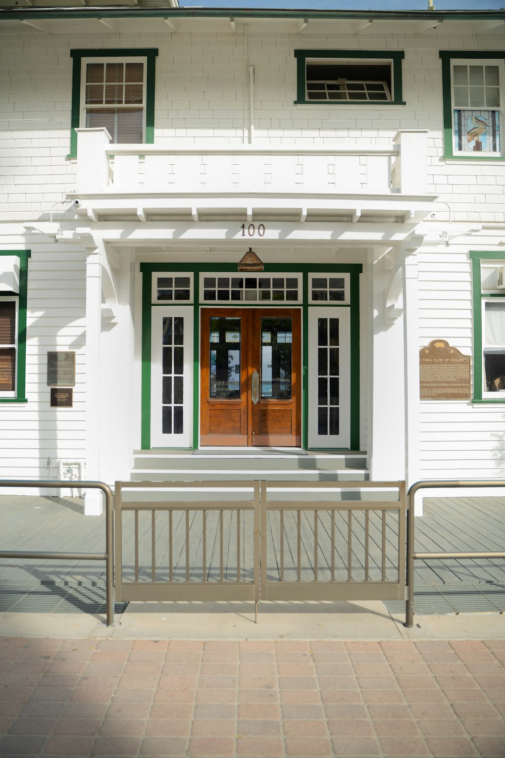 a white building with green trim and a red door