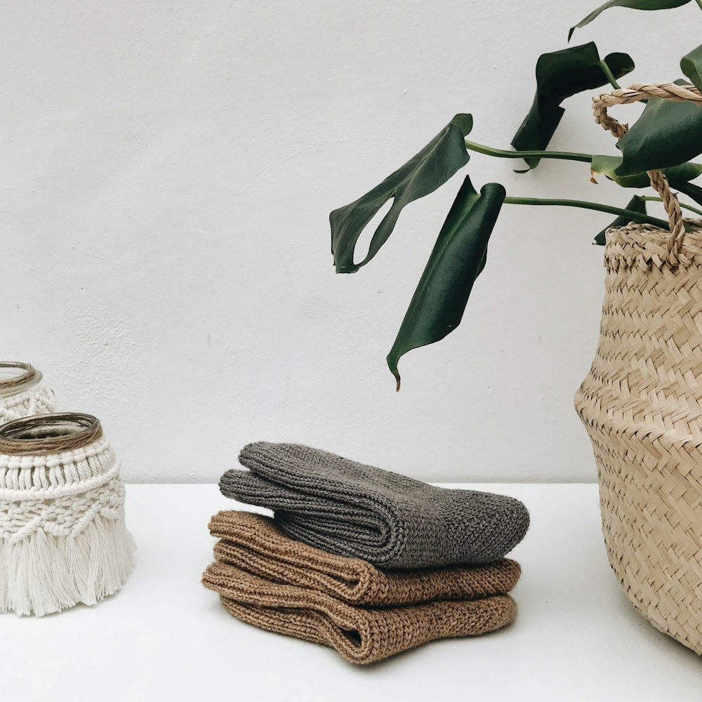 a basket of towels next to a stack of folded towels