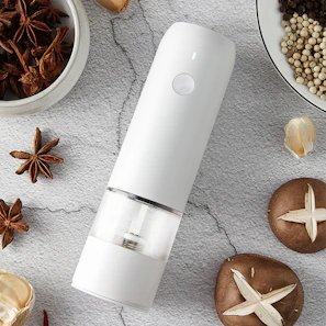 a white device surrounded by spices and nuts
