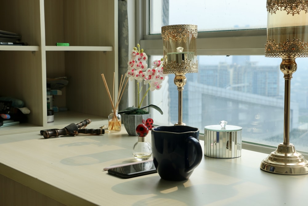 a window sill with a lamp, vase and other items on it