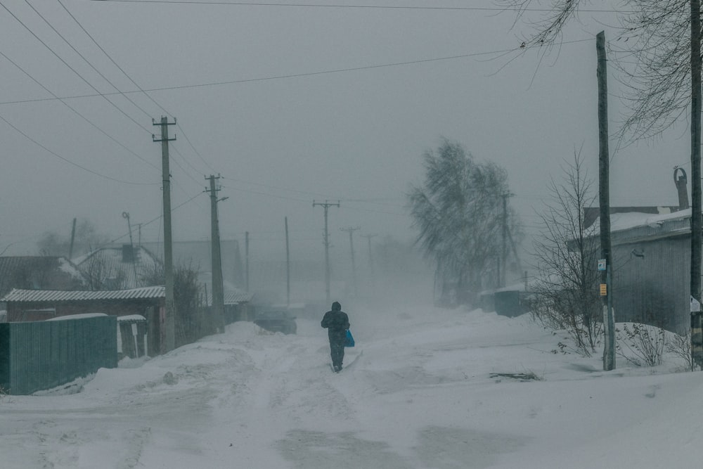 uma pessoa andando por uma rua coberta de neve