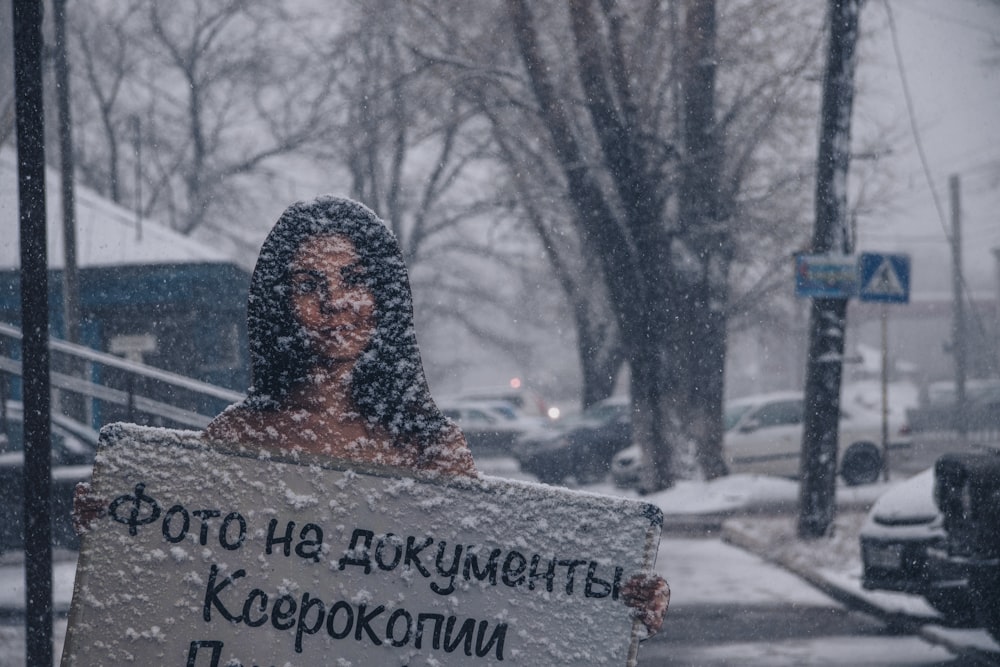 a person holding a sign in the snow