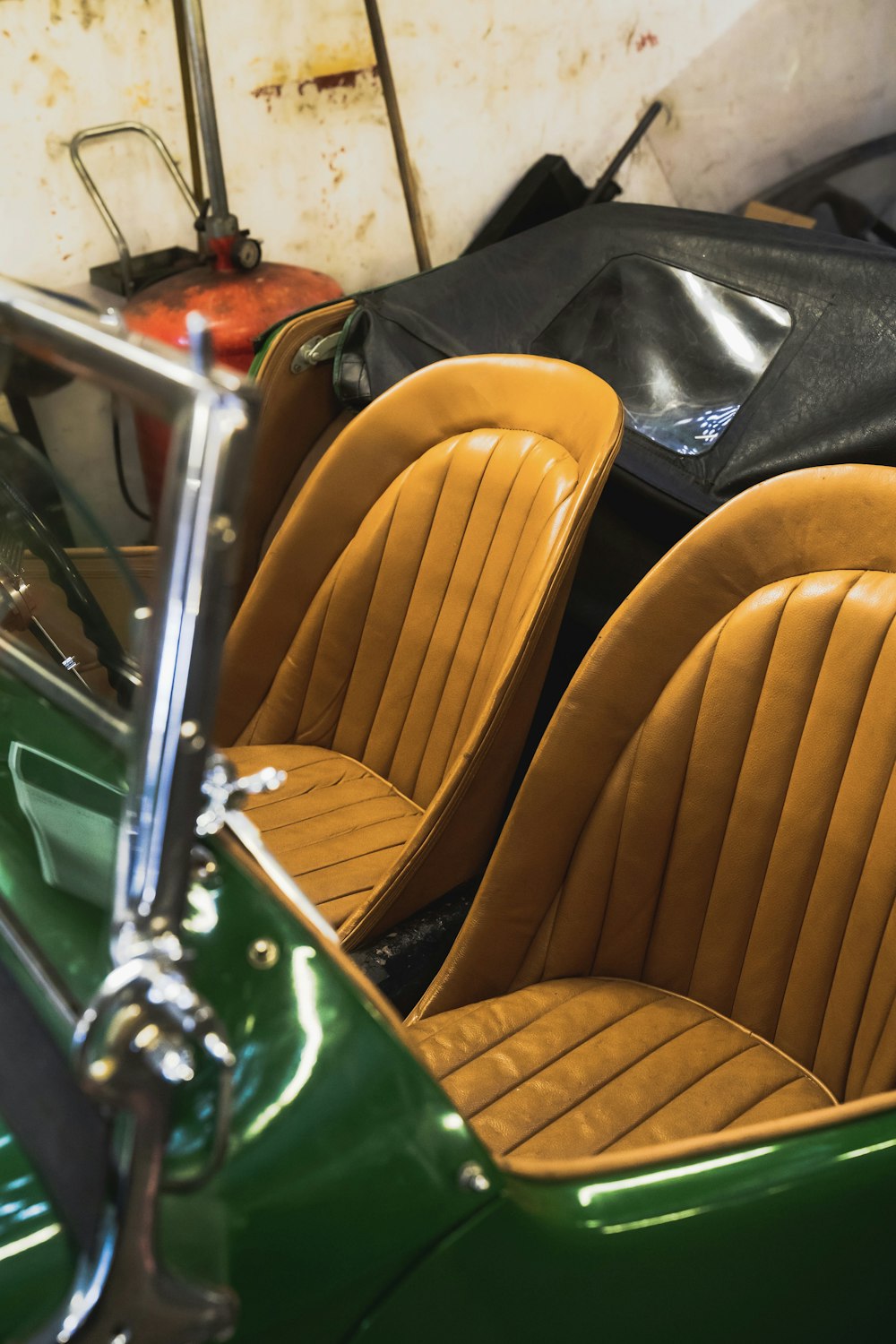 a green car with brown seats and a black bag