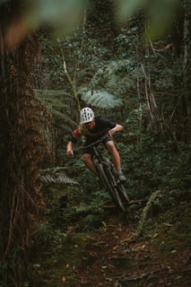 A rider navigating through a dense forest path.