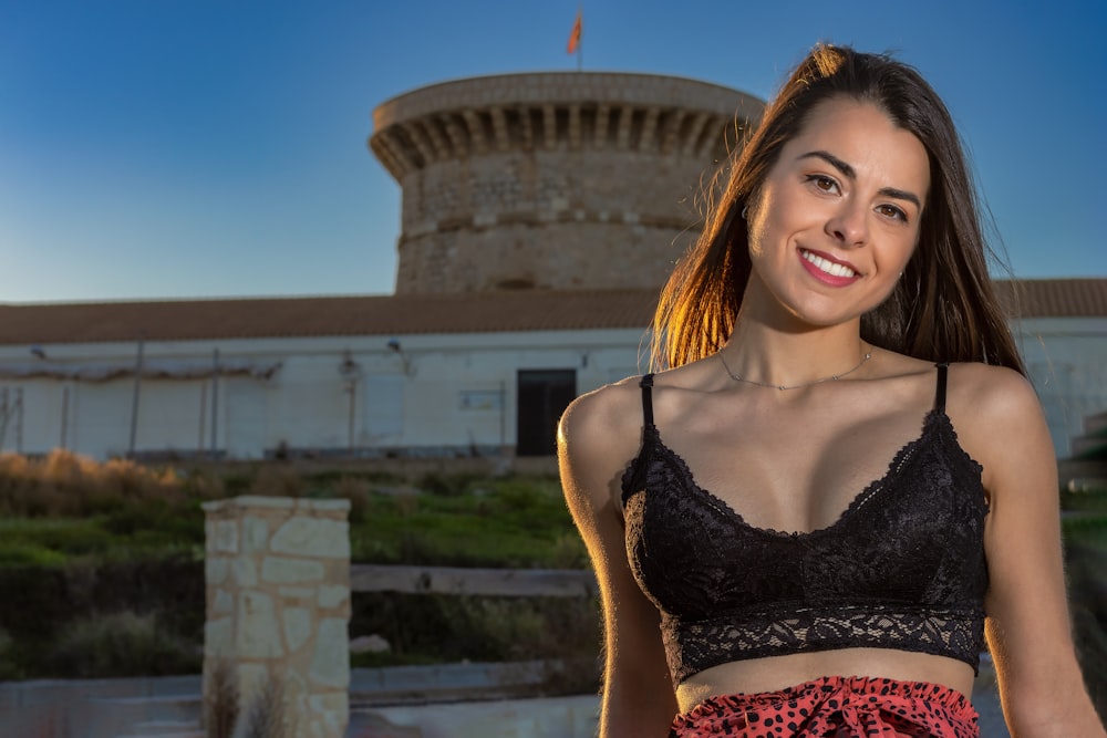 a woman standing in front of a building wearing a bra