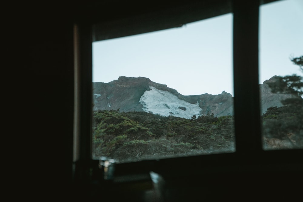 a view of a snowy mountain from a window