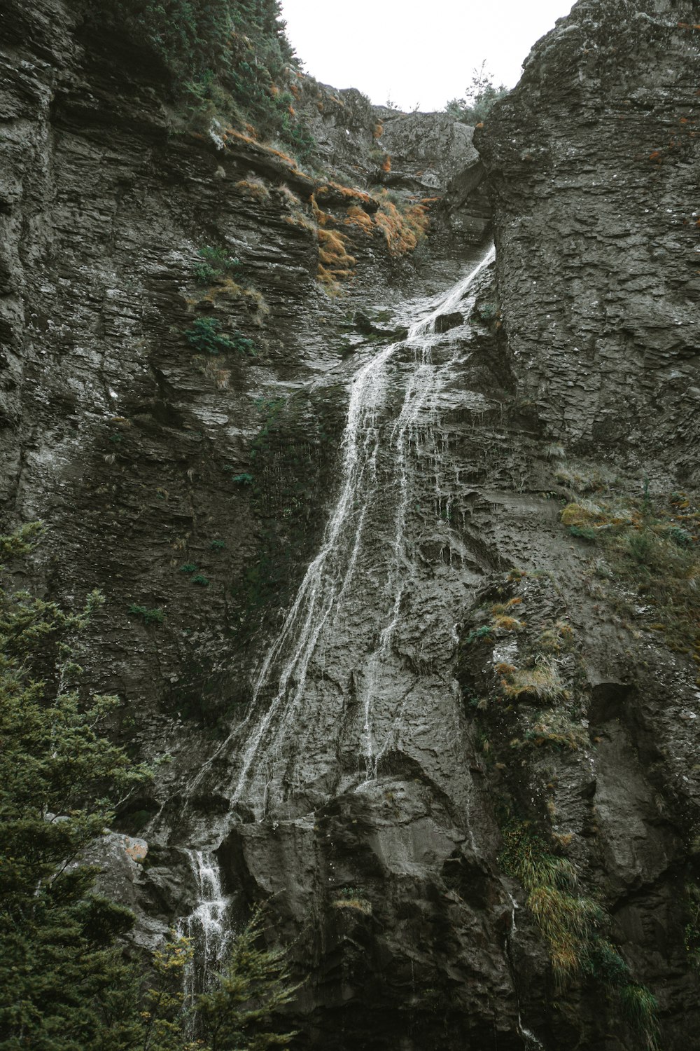 a very tall waterfall in the middle of a mountain