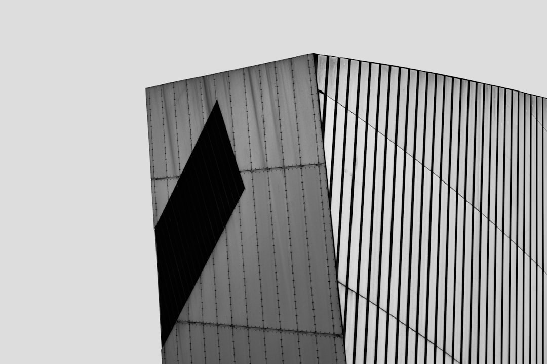 a black and white photo of a tall building, The Imperial War Museum, Manchester, UK.