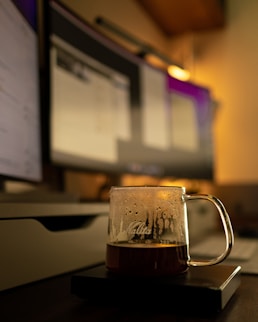 a mug of beer sitting on top of a wooden table