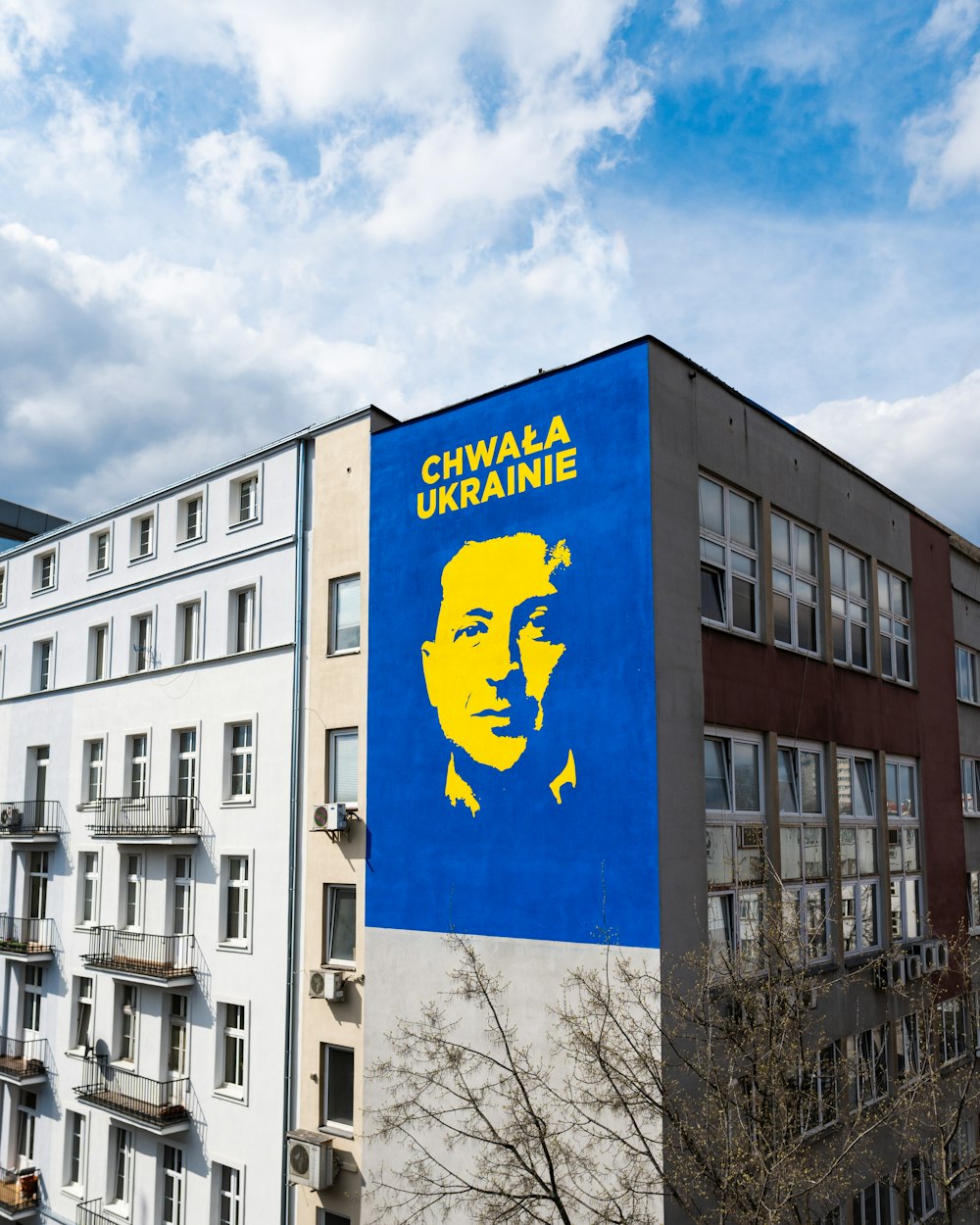 Un edificio con un murale blu e giallo del volto di un uomo