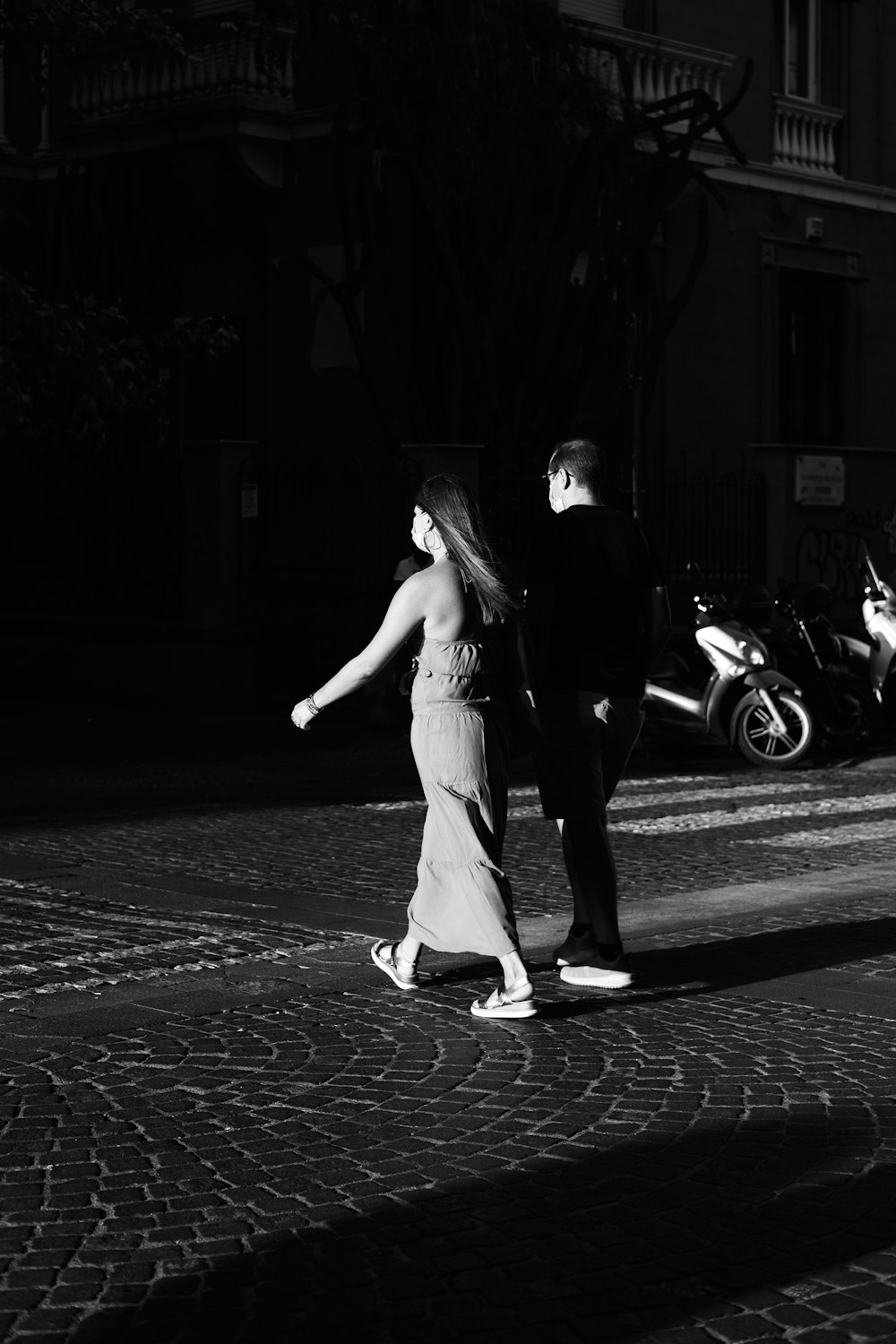 um homem e uma mulher andando por uma rua