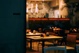 Cozy Scandinavian-style restaurant interior with warm lighting and wooden tables set for dinner.