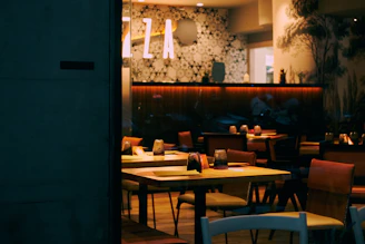 Cozy Scandinavian-style restaurant interior with warm lighting and rustic wooden tables set for dinner.