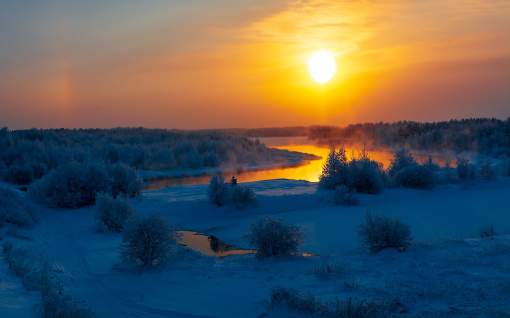 El sol se está poniendo sobre un río congelado