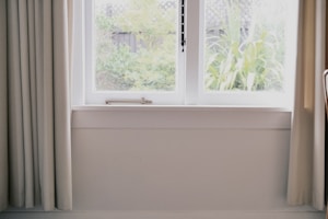 A bright, inviting living room with large windows showcasing a sunny garden outside.
