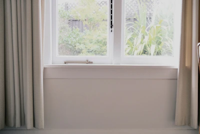 Bright room featuring a large window overlooking a peaceful garden.