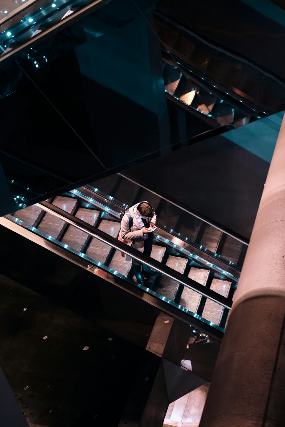 Un homme est assis sur un escalier en verre
