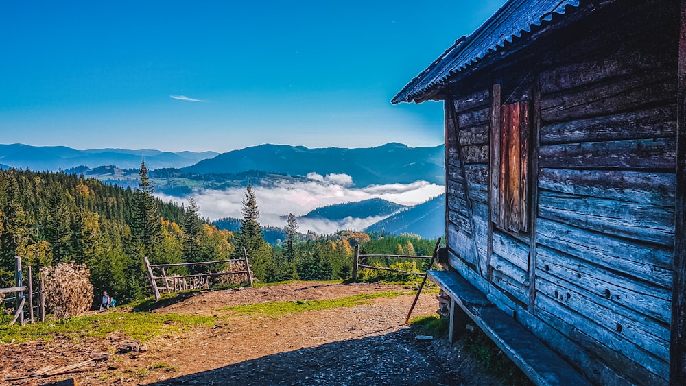 a cabin in the mountains with a view of a valley
