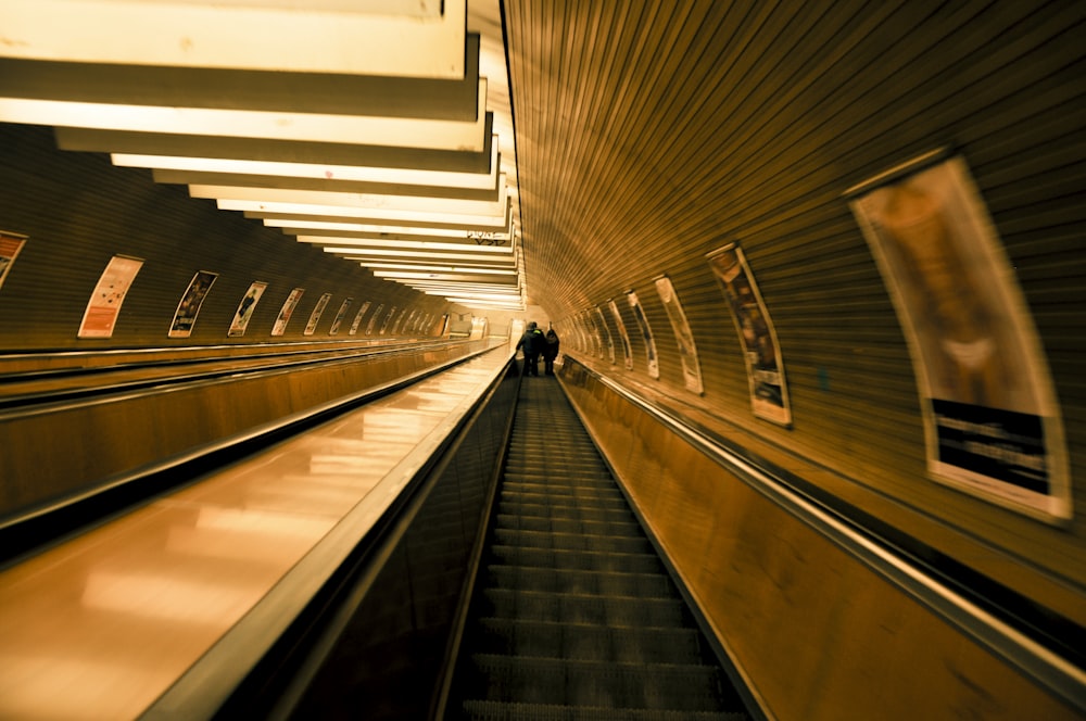 a couple of people riding down an escalator