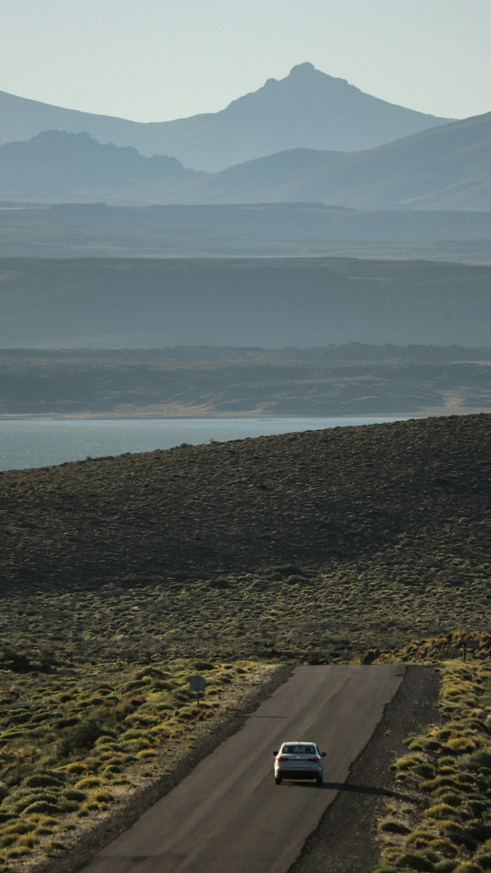 a car driving down a road in the middle of nowhere