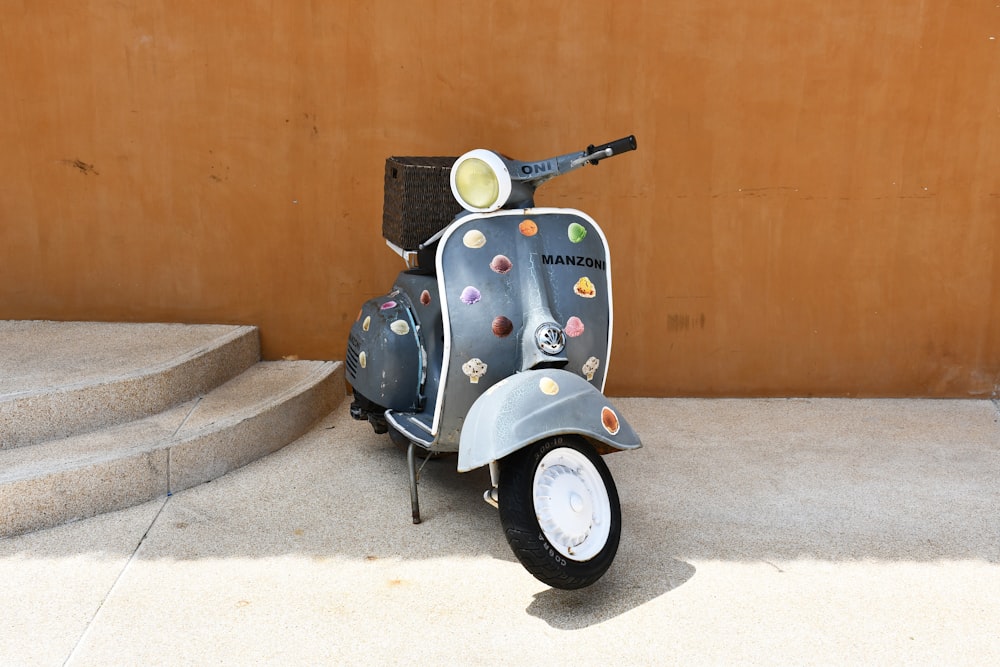 a scooter parked on a sidewalk next to a wall