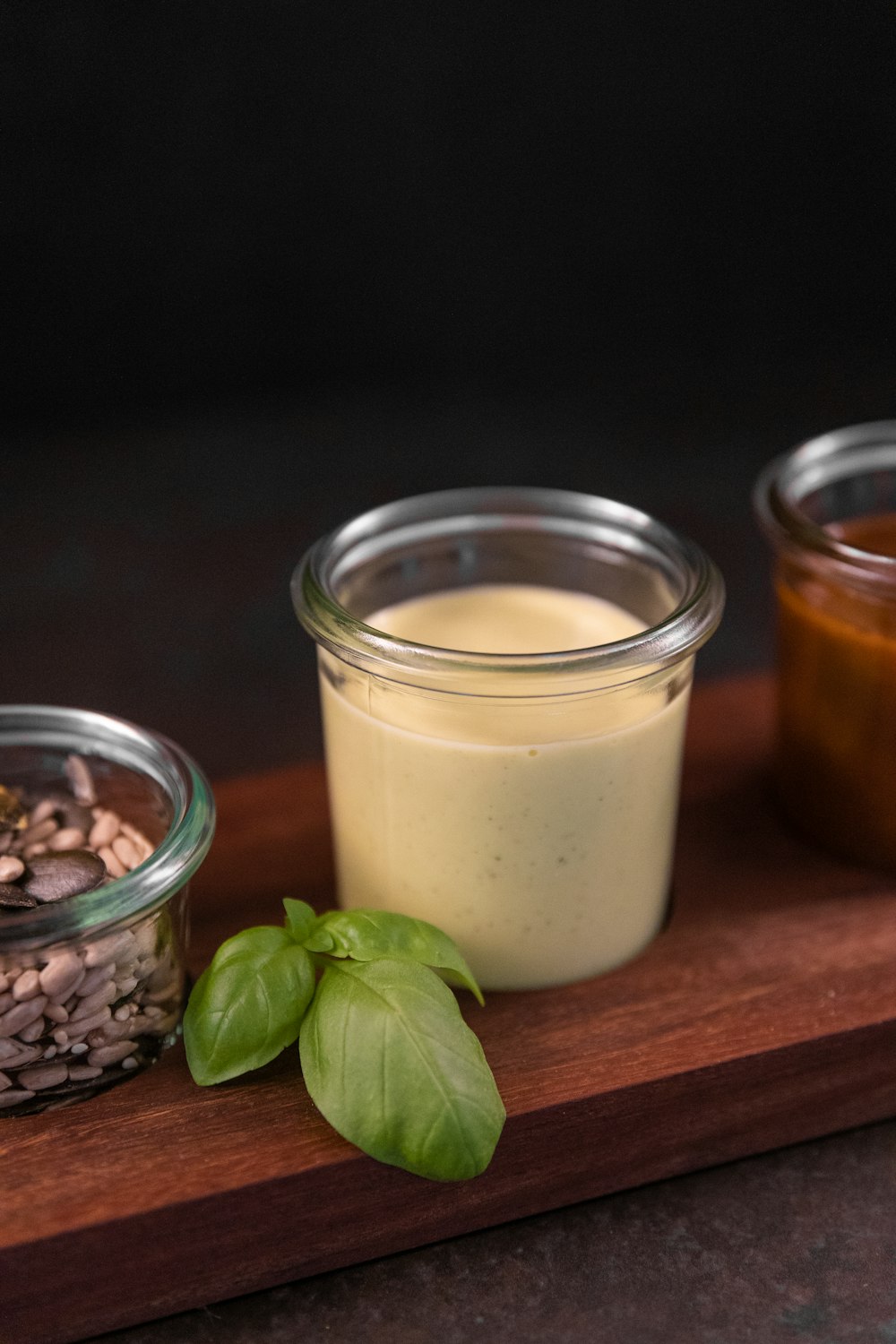 a wooden cutting board topped with jars filled with food