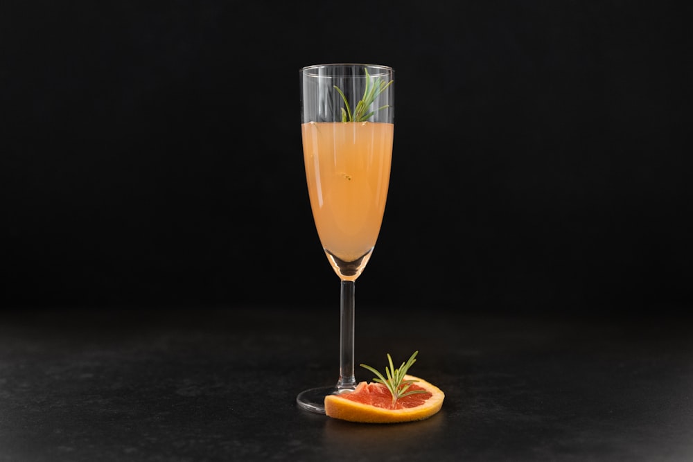 a glass of champagne with a slice of grapefruit