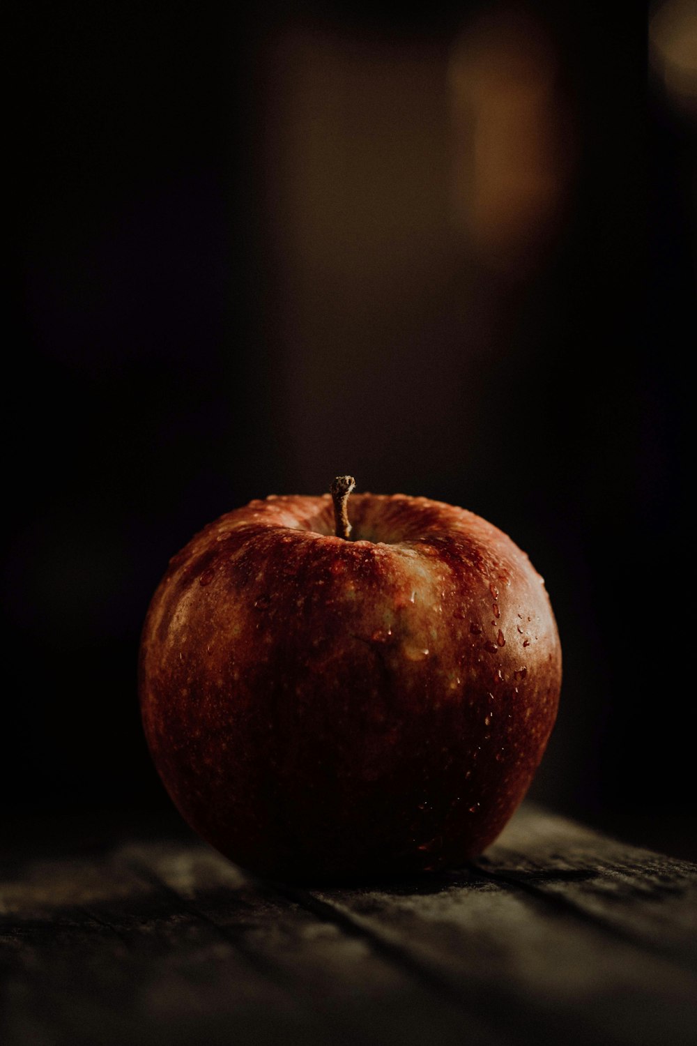 a red apple sitting on top of a wooden table