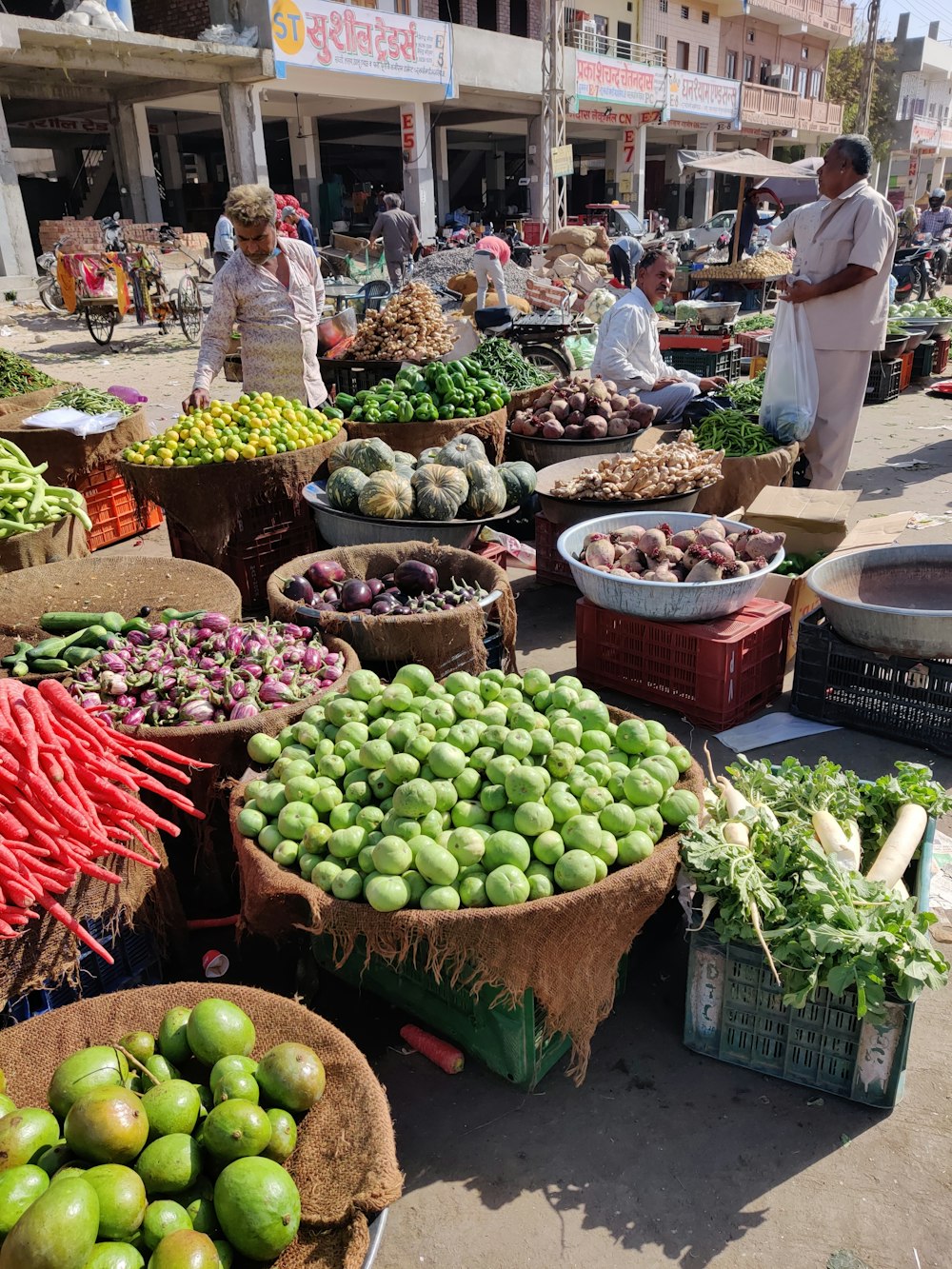 a man standing in front of a market filled with lots of fruits and vegetables